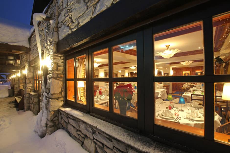Stone-clad dining room with large windows and table seating for groups