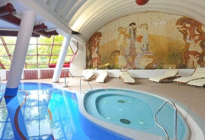 Indoor pool and whirlpool with mural wall and loungers