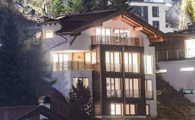 Four-story chalet exterior featuring private balconies and floor-to-ceiling windows