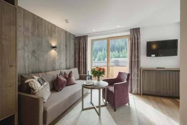 Living area with sofa bed and balcony access to forest views