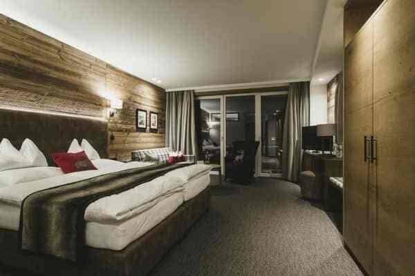 Primary bedroom with king bed, balcony access, and floor-to-ceiling wardrobe