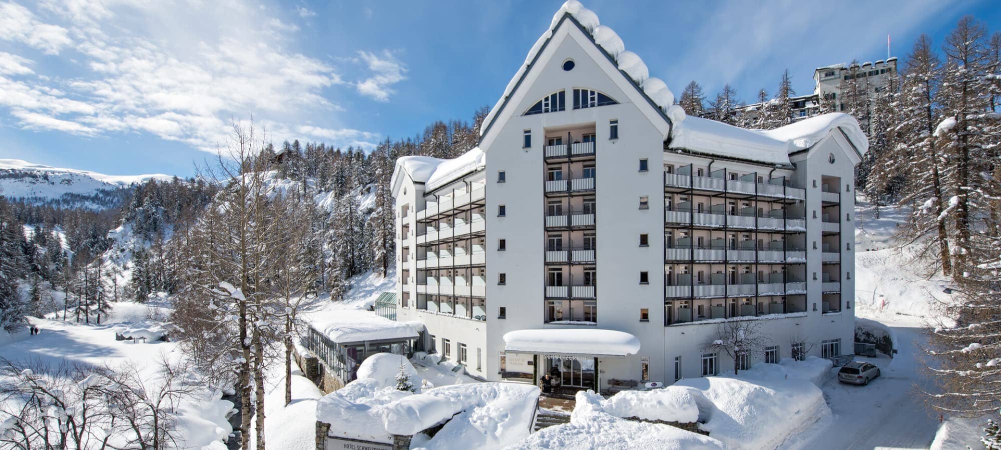 Ski-in/ski-out hotel exterior with private balconies and mountain trail access