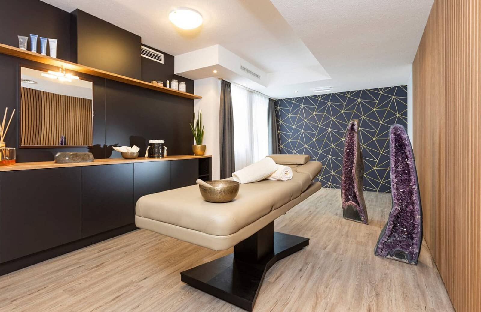 Private spa room with massage table and amethyst geode crystals