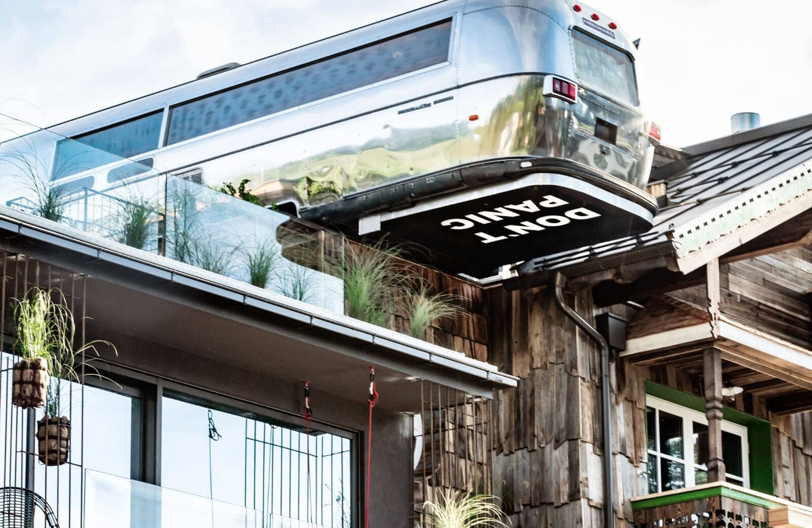 Rooftop Airstream suite cantilevered over the terrace with glass railings