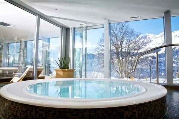 Indoor whirlpool spa with floor-to-ceiling windows and mountain views