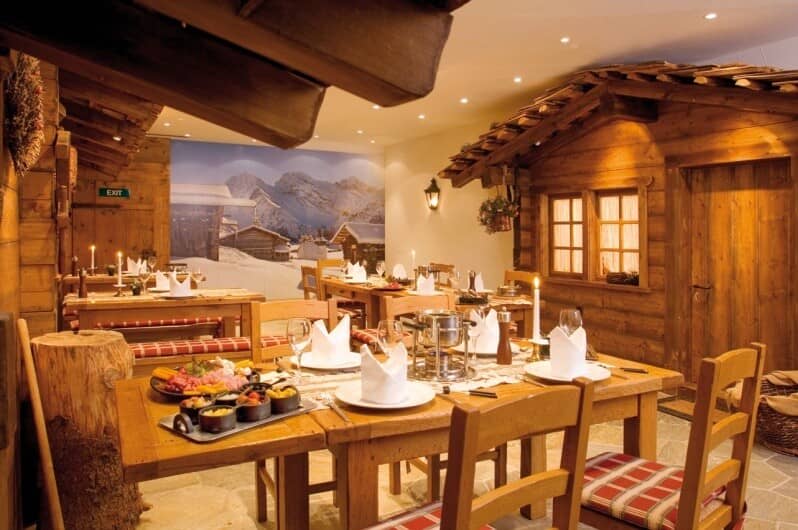 Alpine-themed dining room with fondue setup and wooden chalet interiors