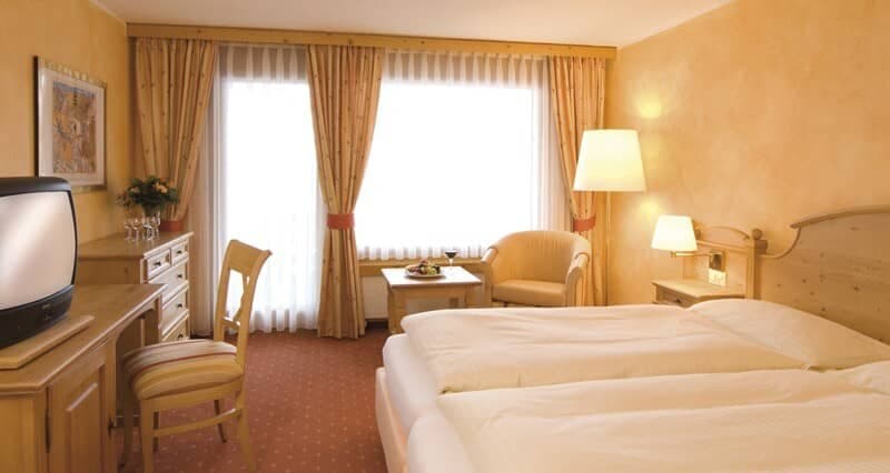 Guest bedroom with twin beds, desk, and balcony access