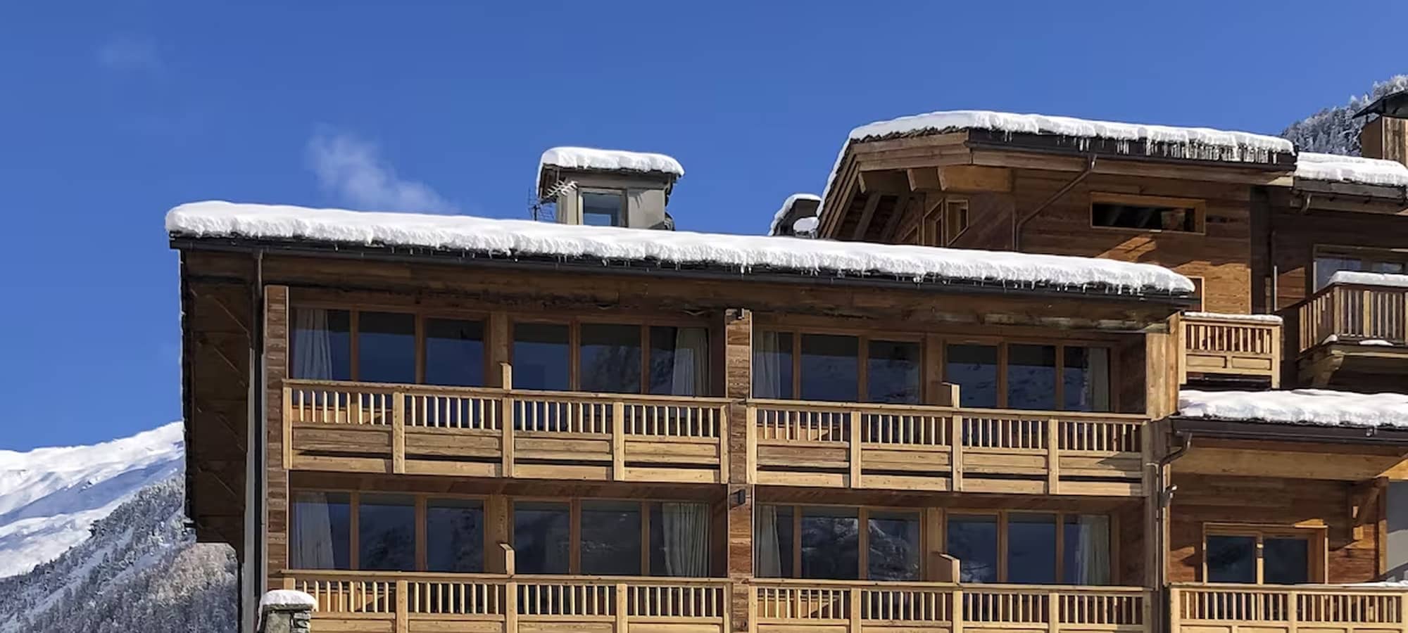 Timber chalet exterior with private balconies and mountain views