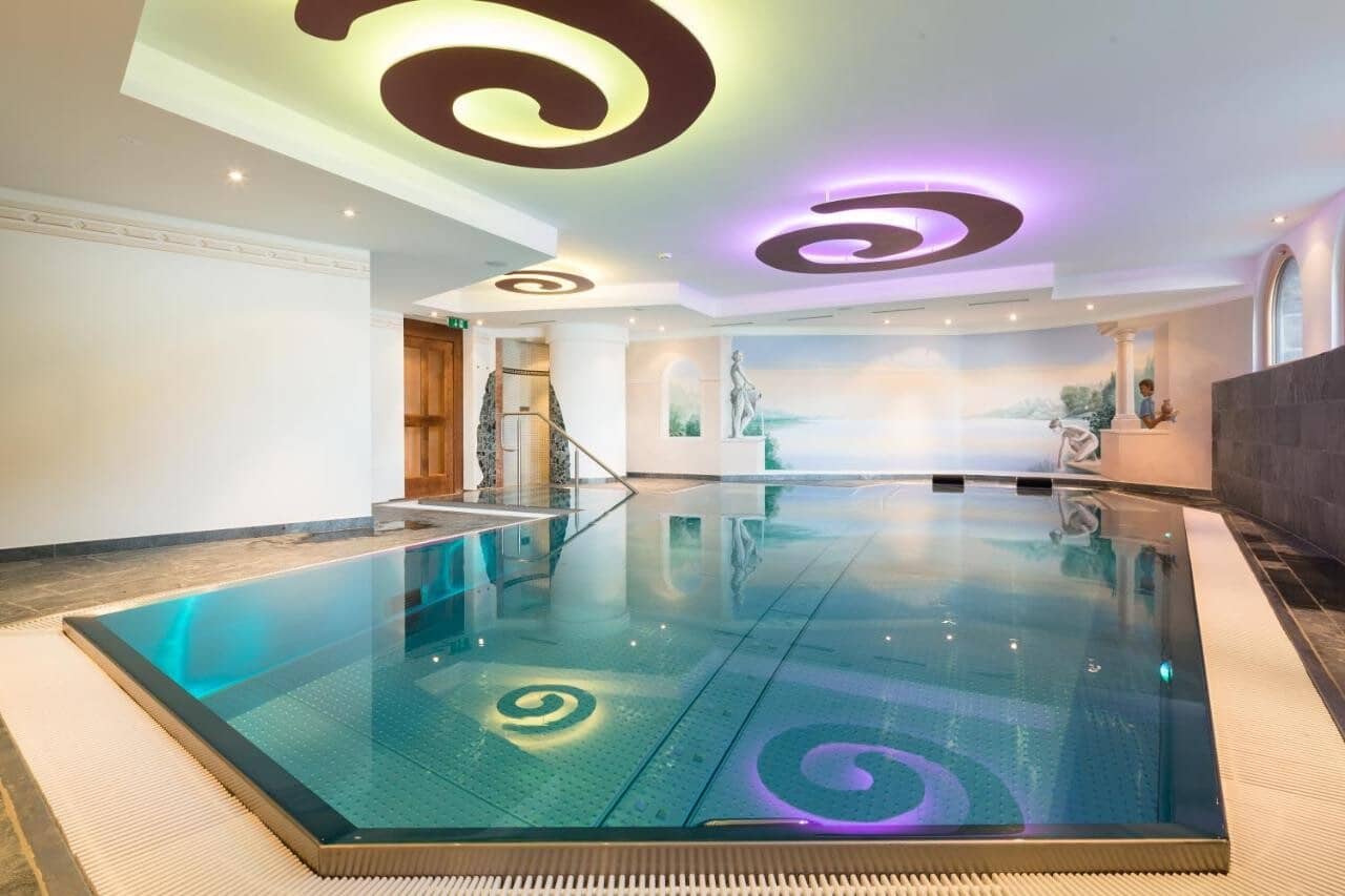 Indoor pool with custom mural and color-changing LED ceiling lighting