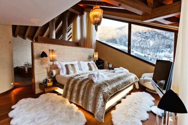 Primary bedroom with king bed, ski mountain views, and ensuite soaking tub