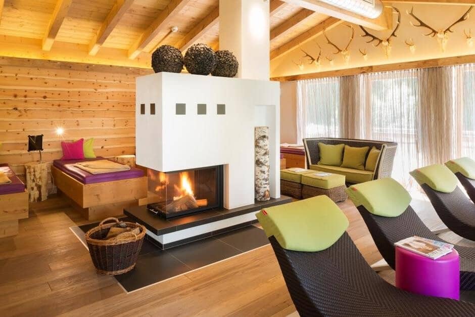 Wellness lounge featuring central glass fireplace and daybed seating