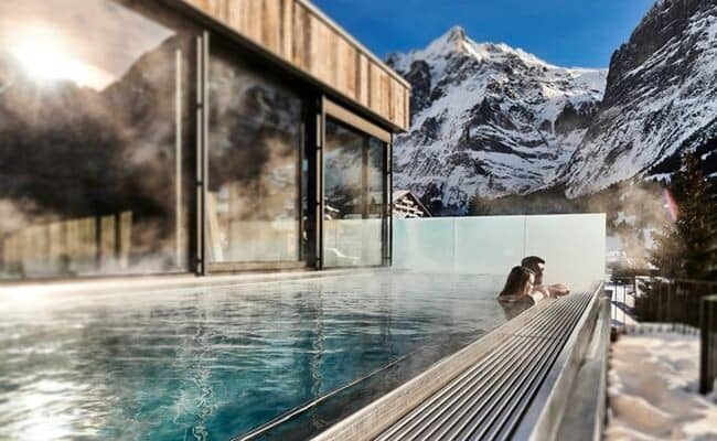 Heated outdoor pool with infinity edge and alpine mountain views