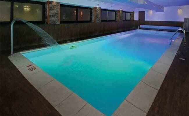 Indoor heated pool featuring waterfall neck shower and automatic safety cover