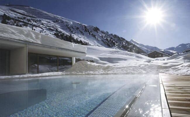 Heated outdoor infinity pool with mountain and ski slope views