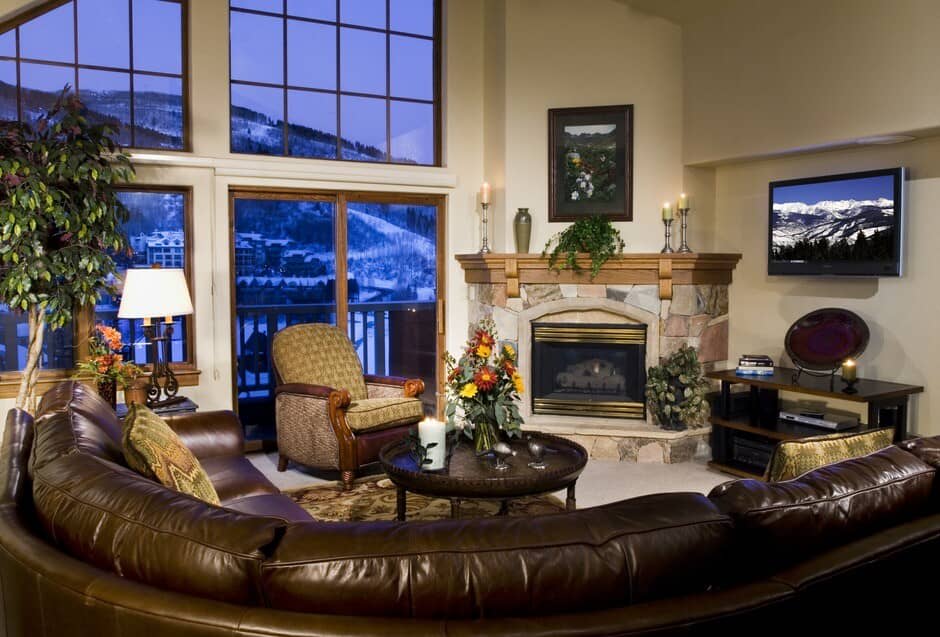 Living room with gas fireplace and floor-to-ceiling windows showing ski runs
