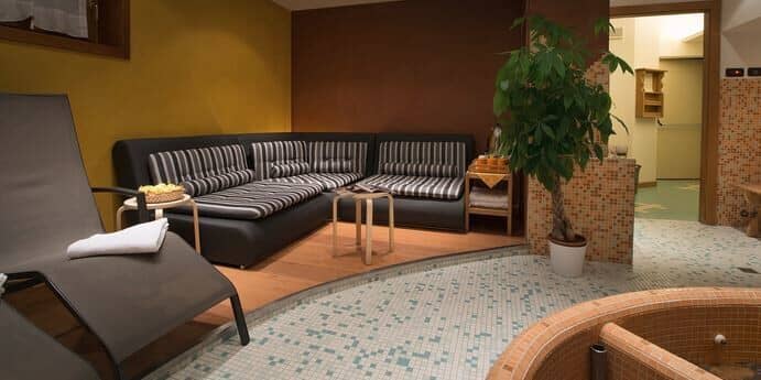 Spa lounge area with sectional seating and heated tile flooring