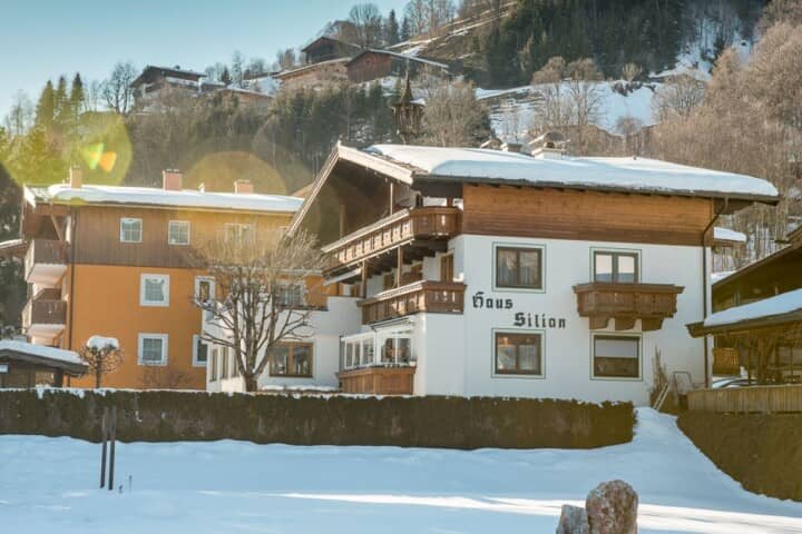 Chalet exterior with multiple balconies and direct snowy meadow access
