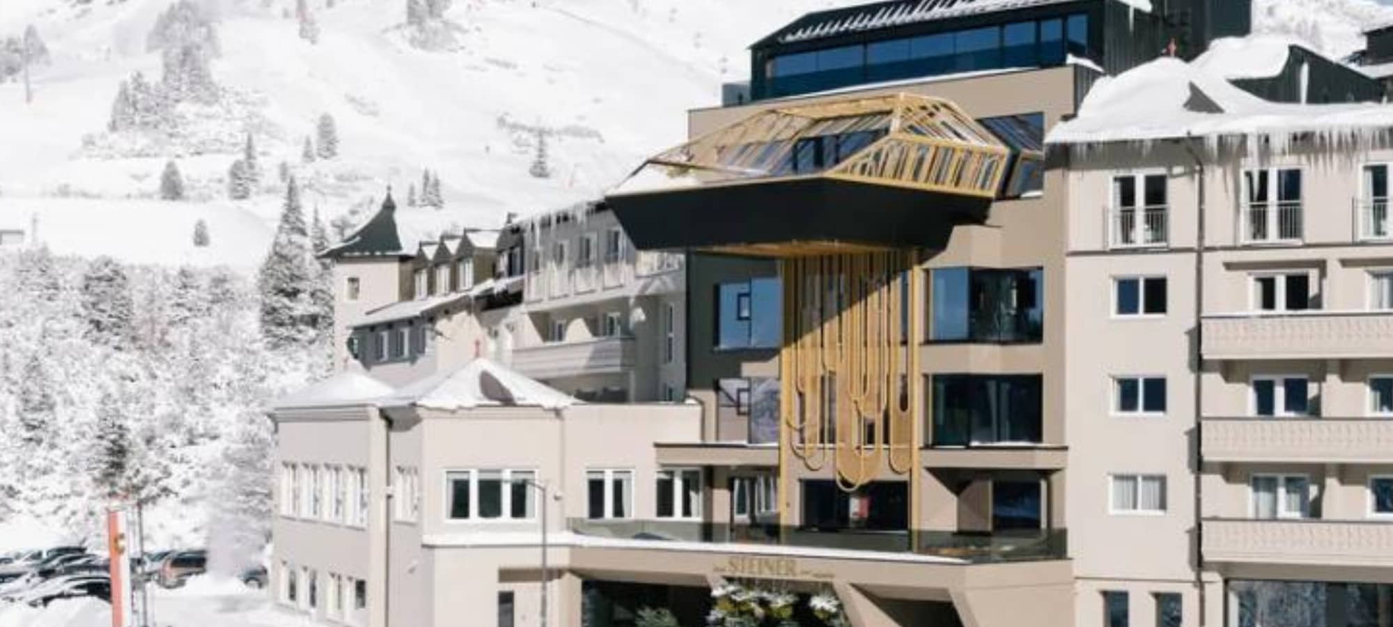 Hotel exterior with cantilevered glass pool and mountain views