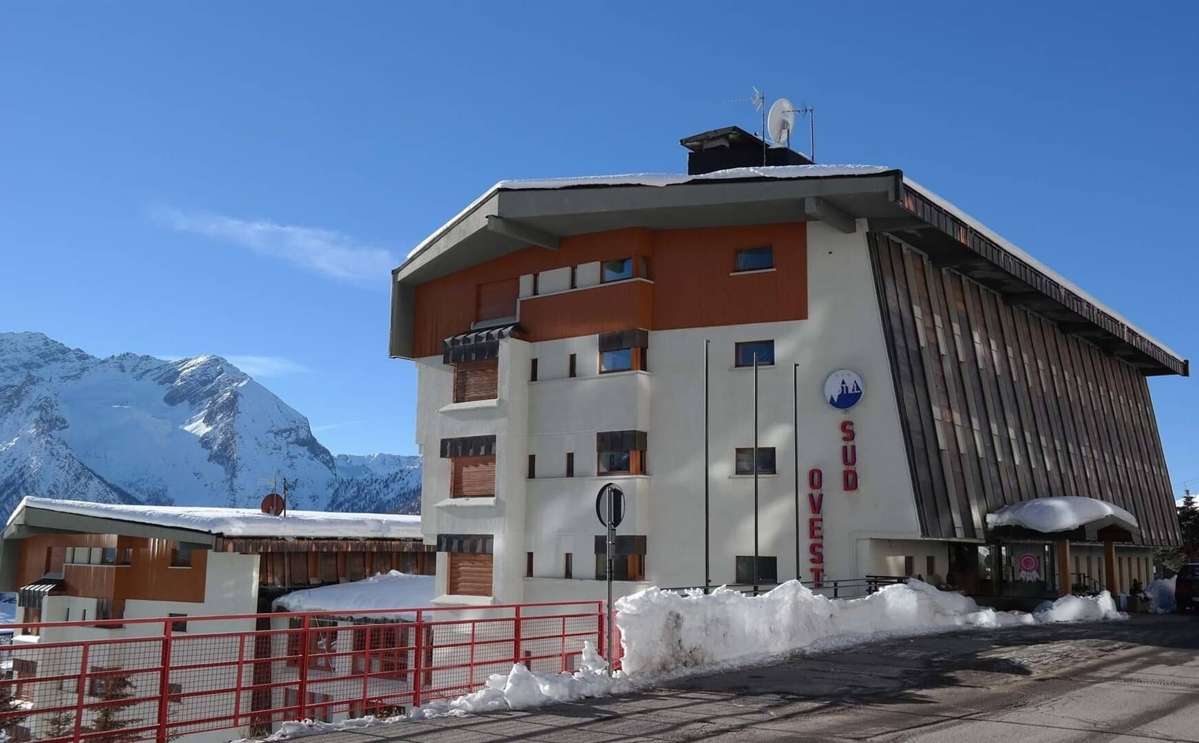 Ovest Sud building exterior with snowy mountain backdrop