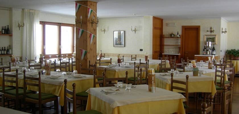 Dining room with multiple set tables and seating for 40 guests