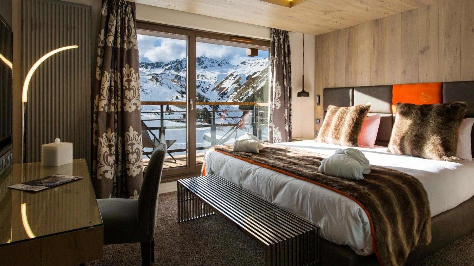 Primary bedroom with king bed and private balcony access to mountain views