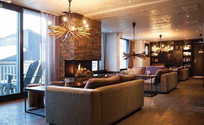 Lounge area with three-sided stone fireplace and terrace access