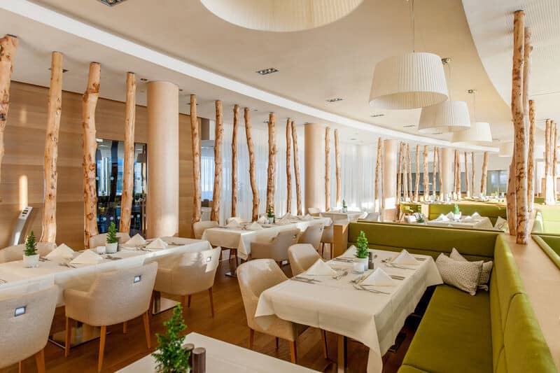 Dining area with booth seating and decorative birch tree room dividers