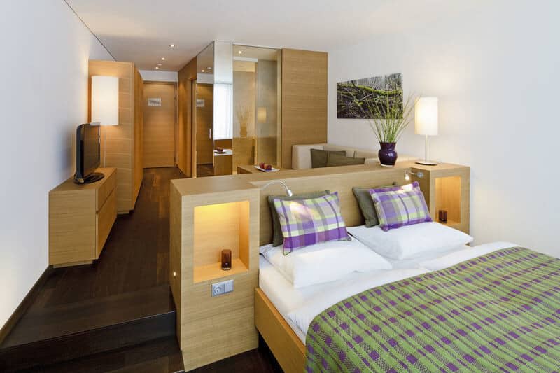 Studio layout with queen bed, integrated storage, and lounge area