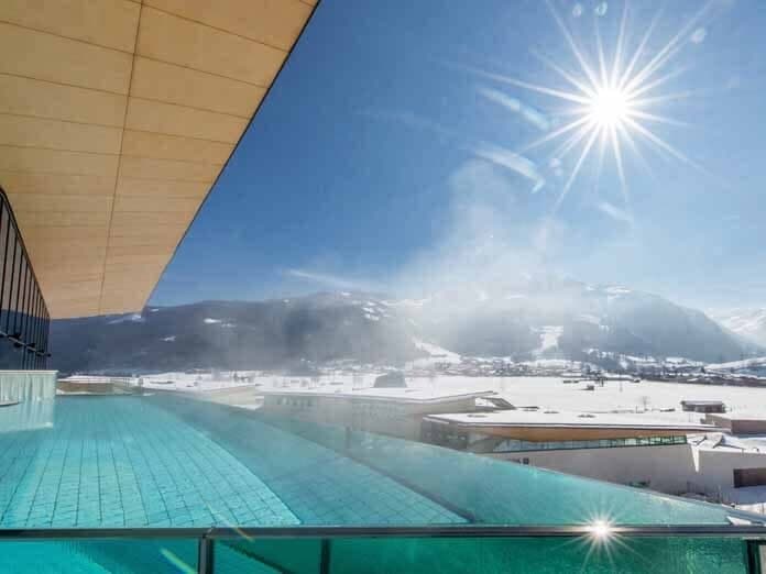 Heated infinity pool with glass edge and panoramic Alpine views