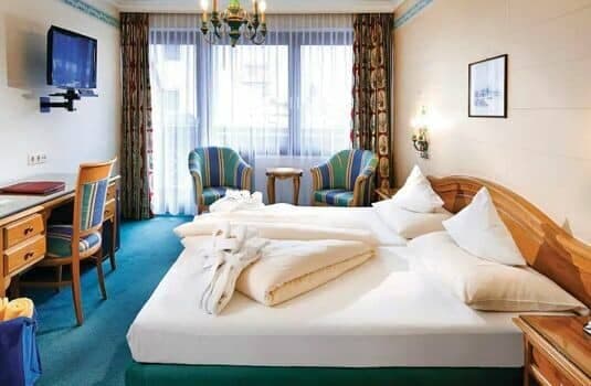 Guest room with side-by-side twin beds, desk, and window seating