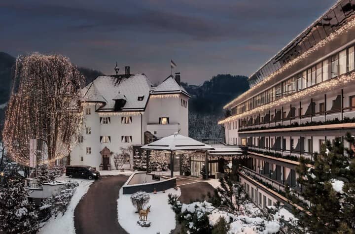 Hotel exterior with covered entrance and balcony views of the mountains