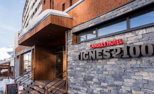 Hotel entrance with stone facade and steps near the ski slopes