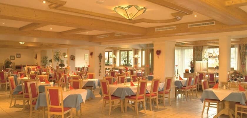 Large dining room with set tables and beamed ceilings