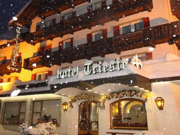 Hotel exterior featuring private balconies and illuminated snow-covered entrance