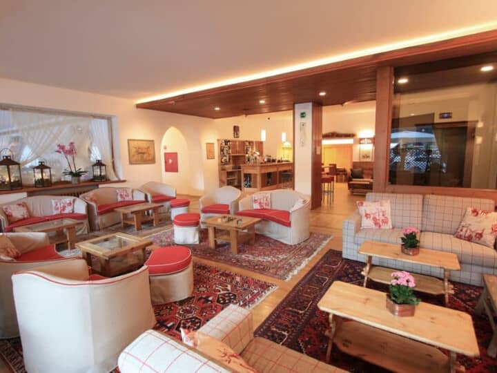 Shared lounge area featuring multiple seating clusters and background cocktail bar