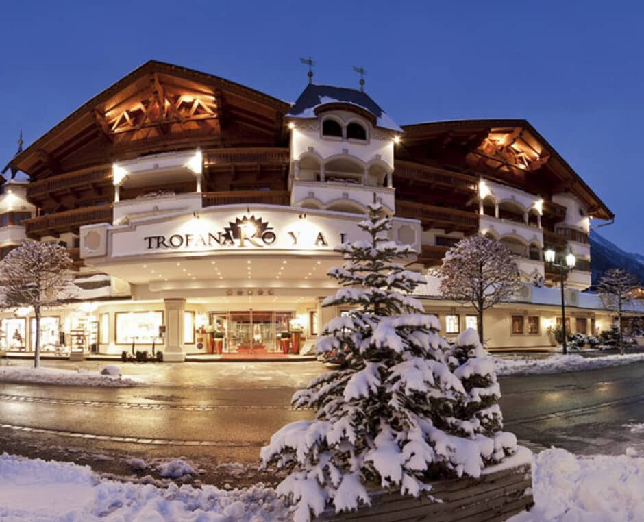 Hotel exterior featuring private balconies and lit entryway; located near street level
