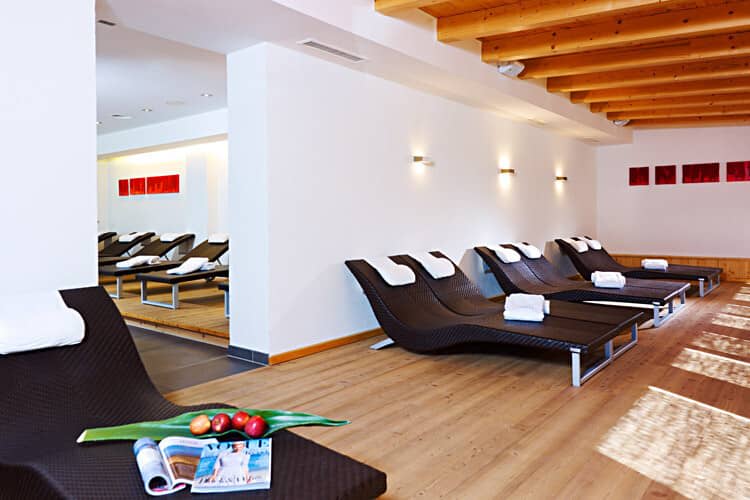 Spa relaxation room with heated loungers and exposed wood beams