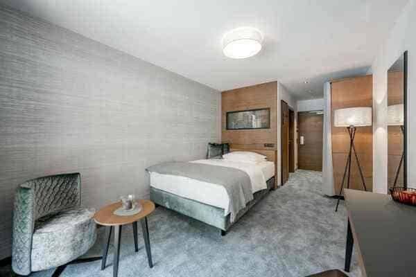 Guest bedroom with single bed, velvet armchair, and workspace