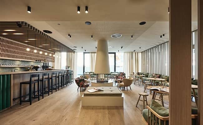 Shared lounge and bar area with central wood-burning fireplace