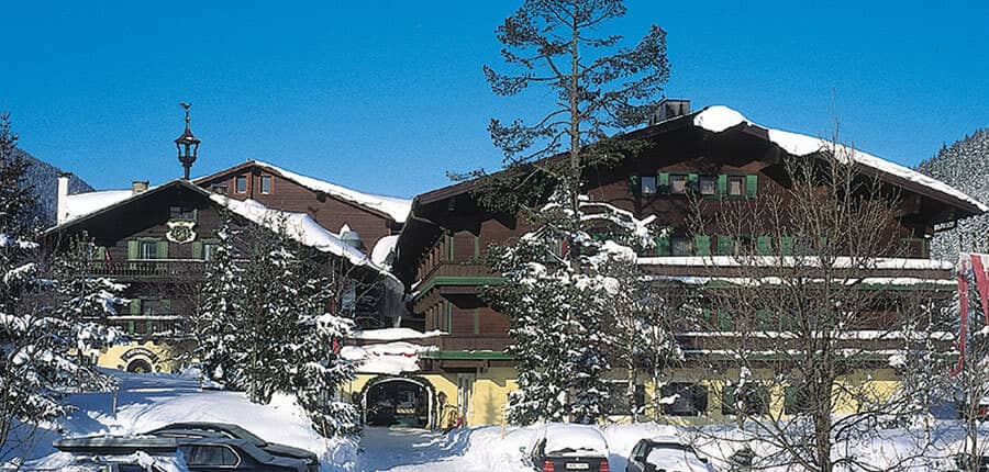 Alpine-style chalet with tiered wood balconies and traditional green shutters