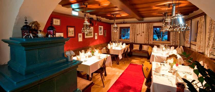 Dining room with traditional tiled stove and cowbell pendant lights
