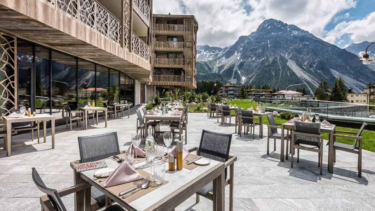 Outdoor terrace dining with mountain peak views and table service