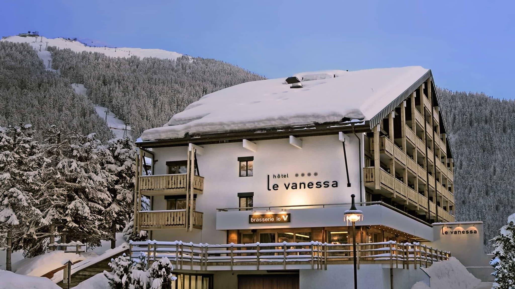 Hotel exterior featuring private balconies and on-site brasserie with ski hill access