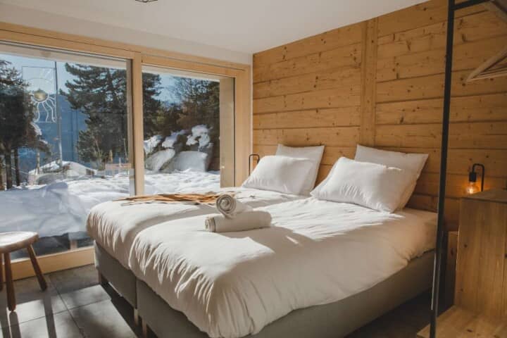 Guest bedroom with twin beds and floor-to-ceiling snow views
