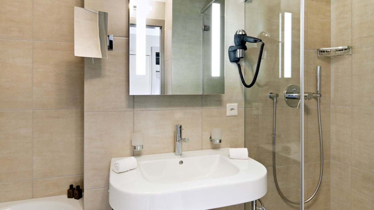 Bathroom with walk-in shower and wall-mounted hair dryer
