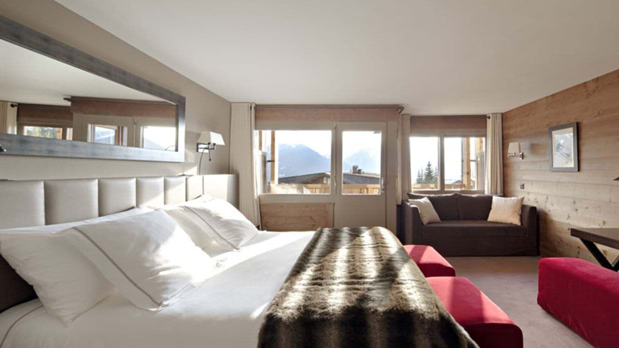 Primary bedroom with king bed, sofa seating, and mountain views