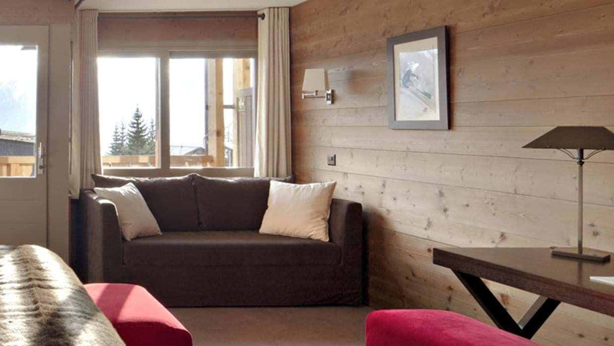 Guest bedroom with sofa bed, workspace, and balcony access