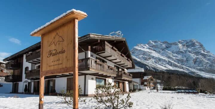 Chalet exterior with private wooden balconies and views of snow-capped peaks