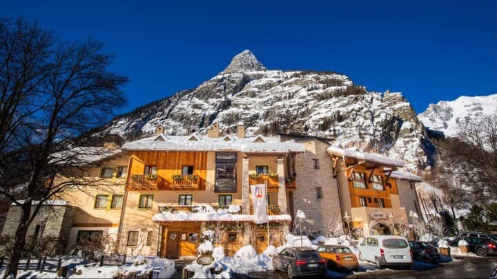 Chalet exterior with private balconies and on-site parking at mountain base