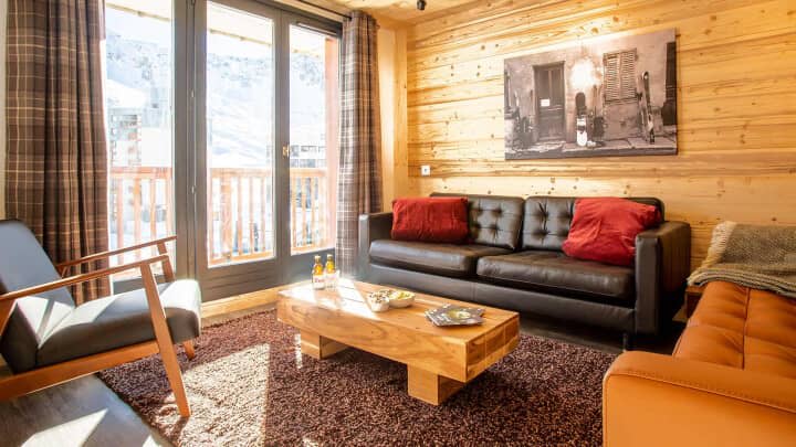 Living area with leather seating and balcony access to mountain views
